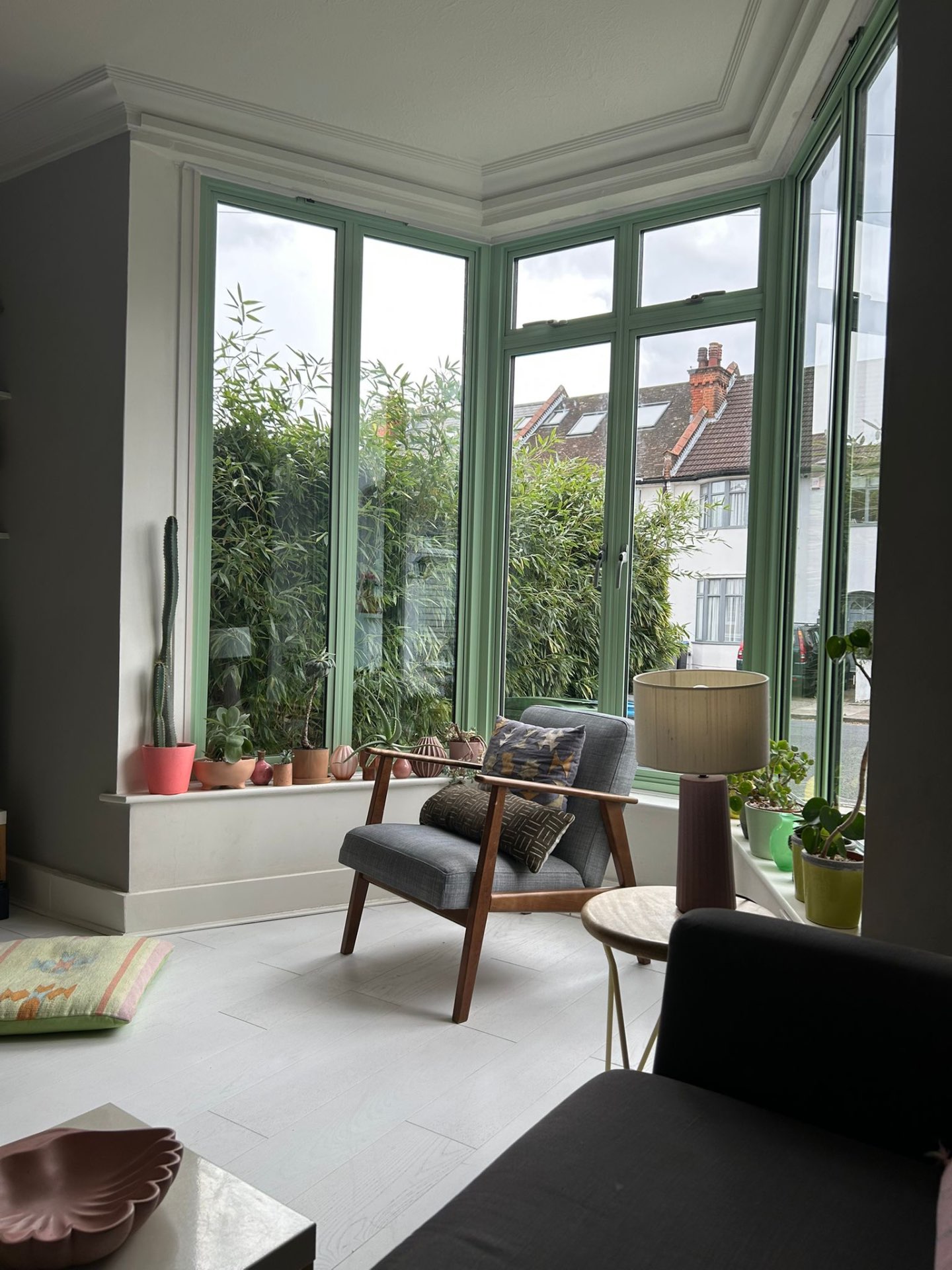 Green-framed bay glazing seen from the living room