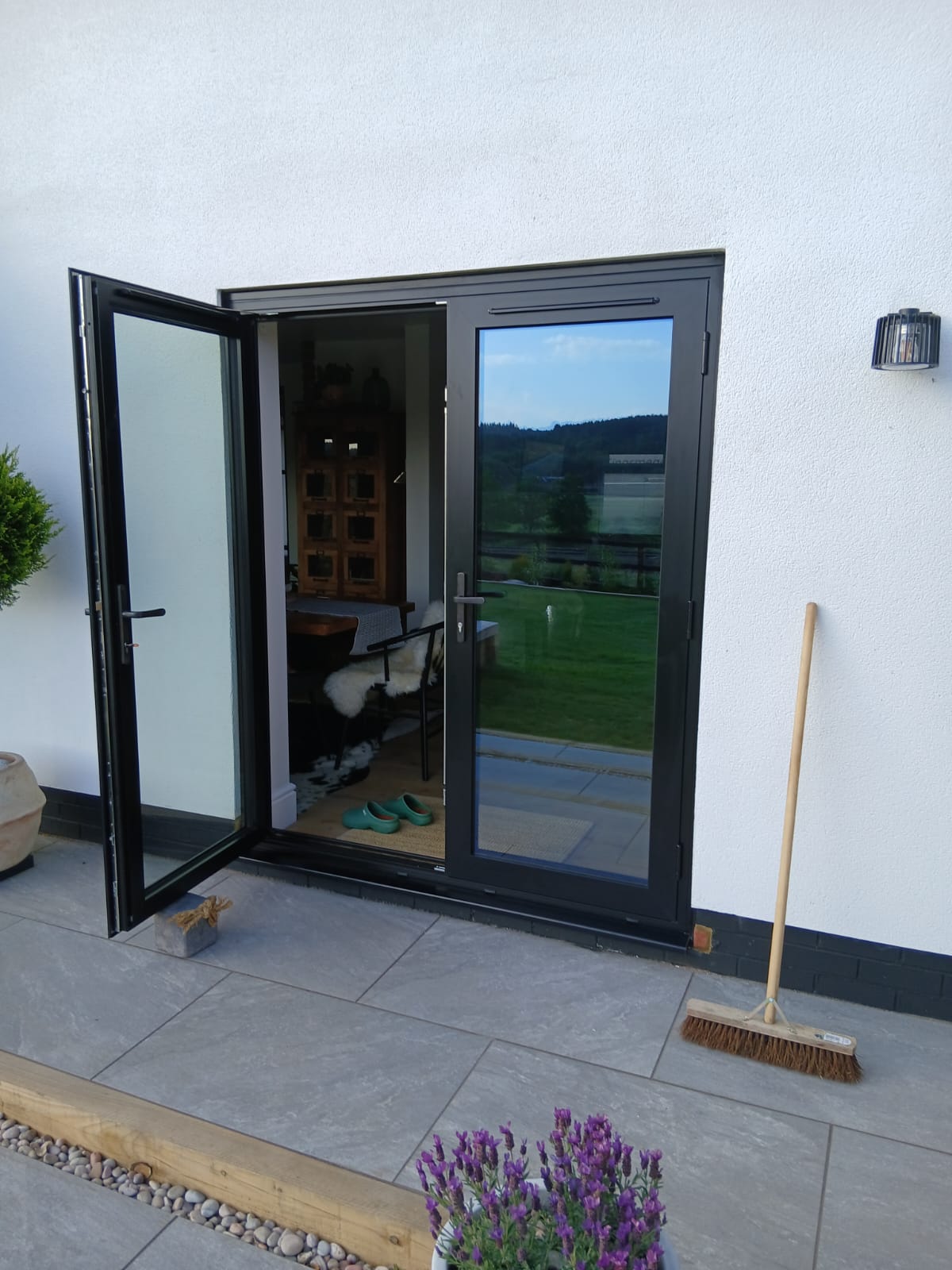Anthracite aluminium French doors onto a stone patio