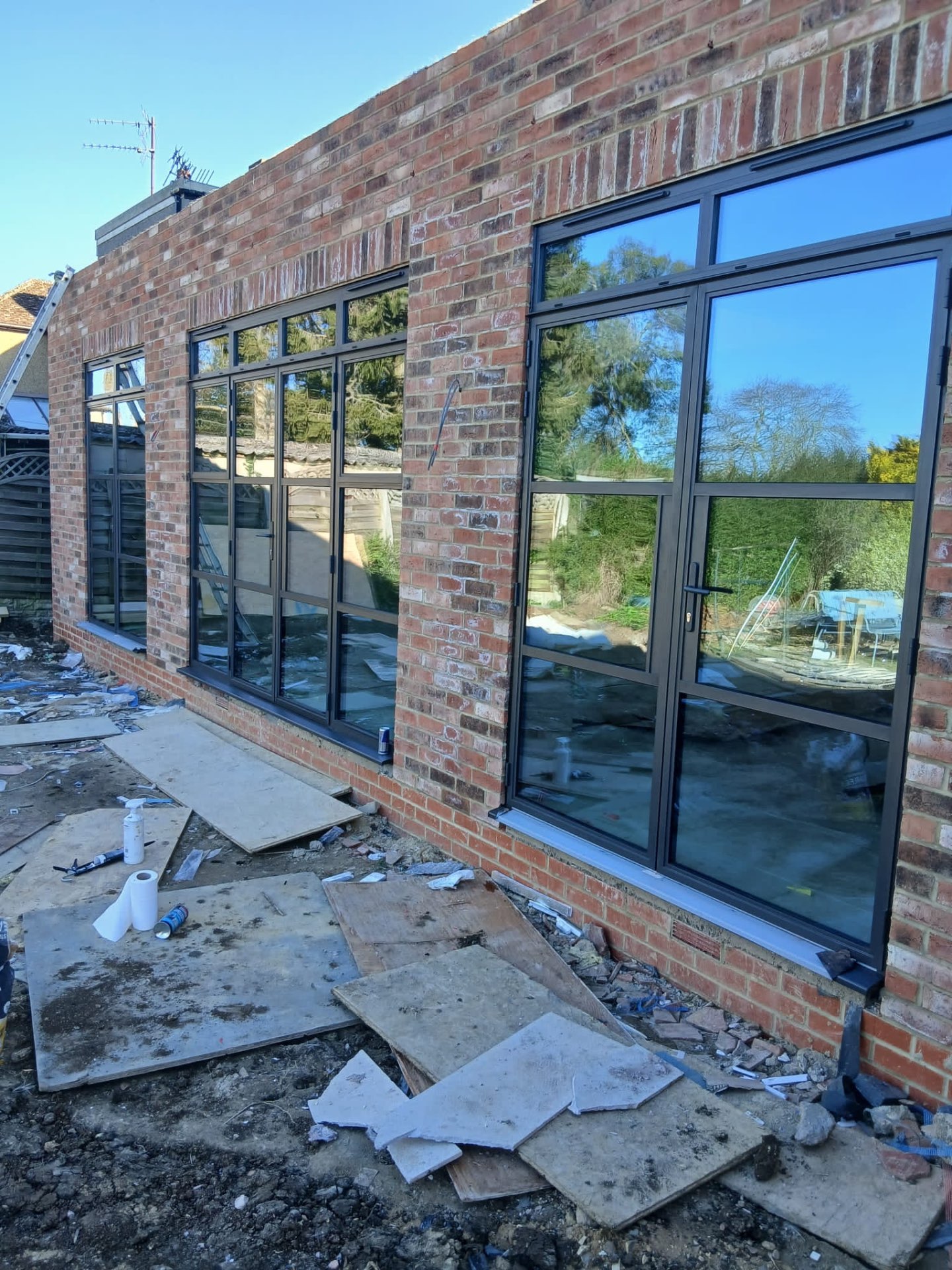 Run of aluminium windows and a side door to a brick extension