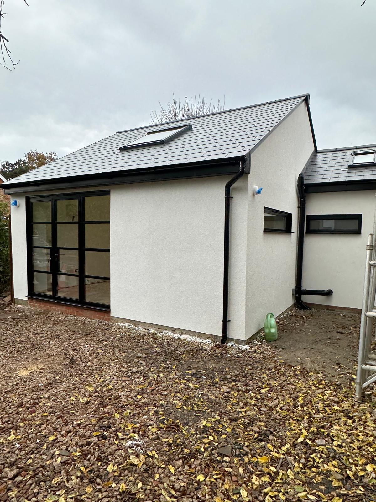 Steel-look French doors to a rendered garden room