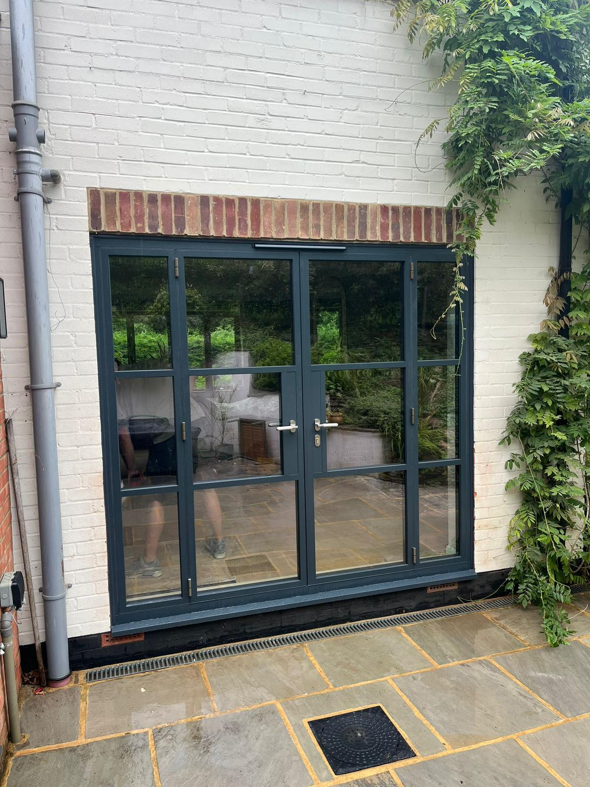 Steel-look French doors with side screens, painted brick