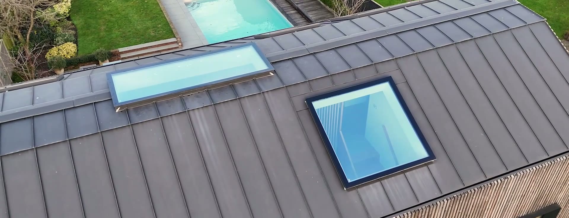Flank elevation — deep-set black frames within the batten rhythm