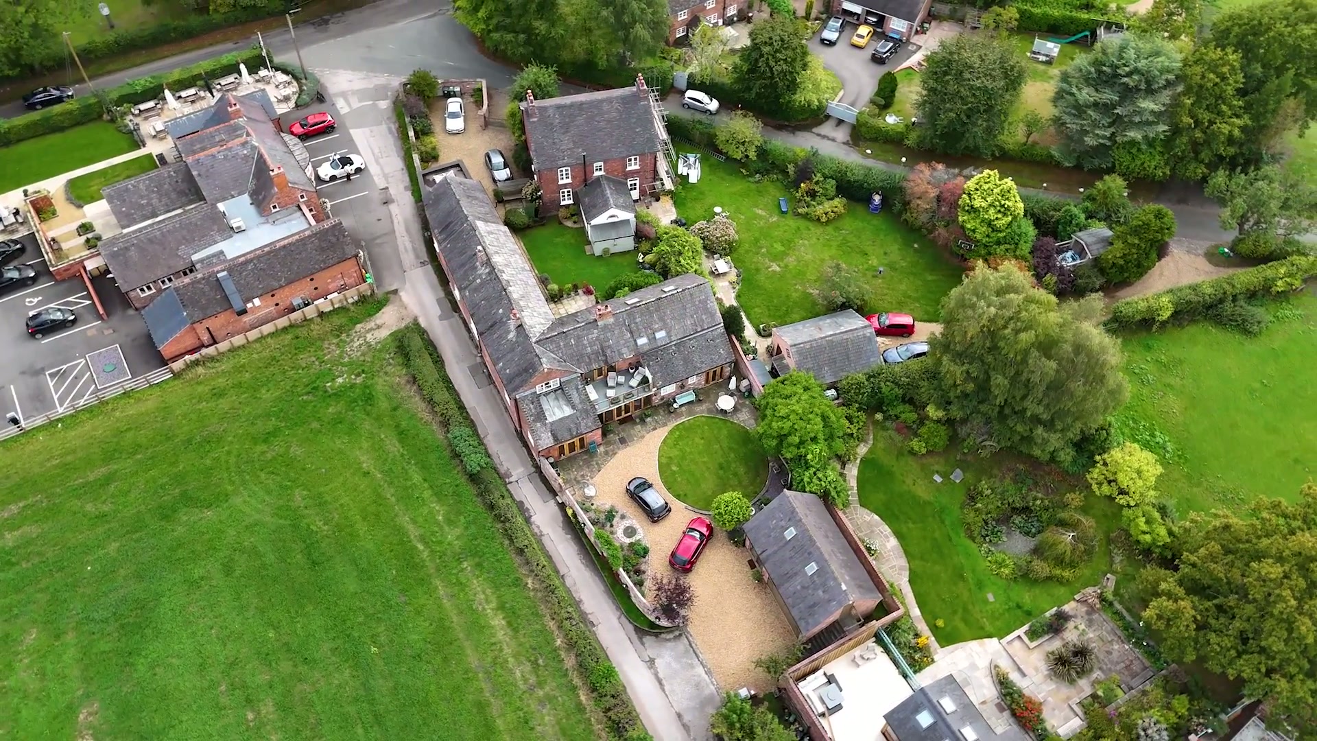 The courtyard range from the air, farm buildings converted around a gravelled yard
