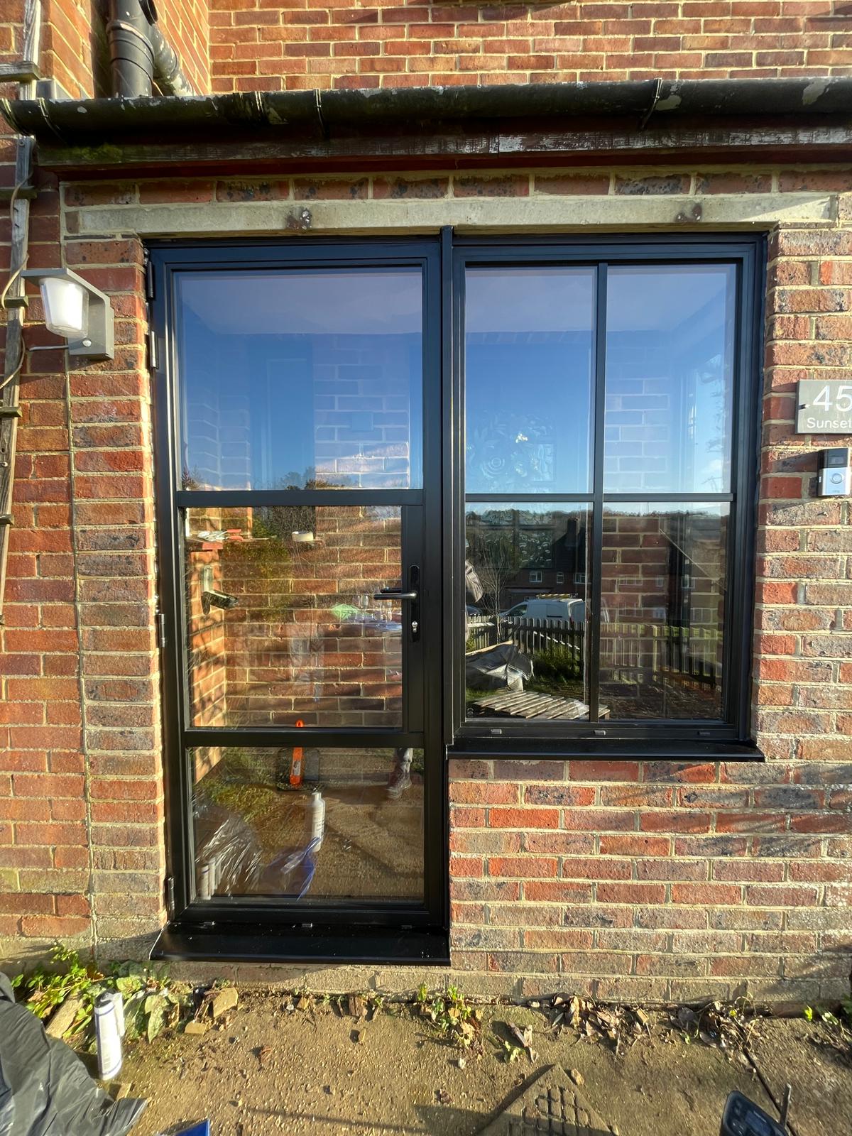 Steel-look door and window set in a brick opening